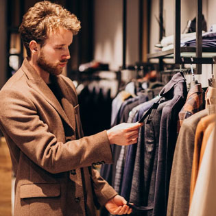 homme qui regarde des chemises dans une boutique 